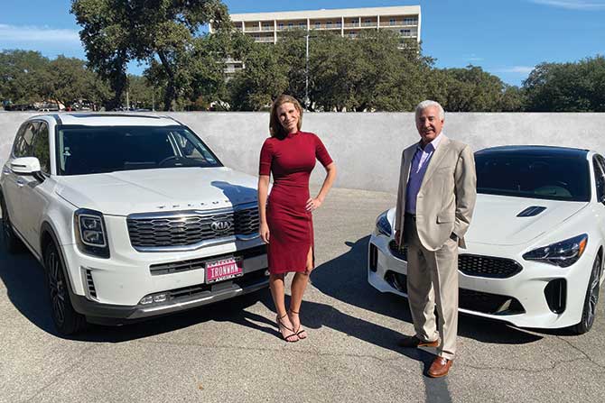 two-people-in-front-of-two-cars