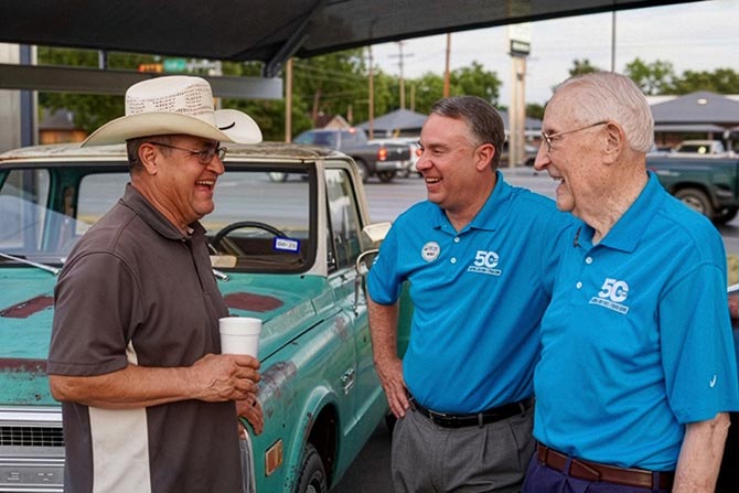 Three men in front of a car