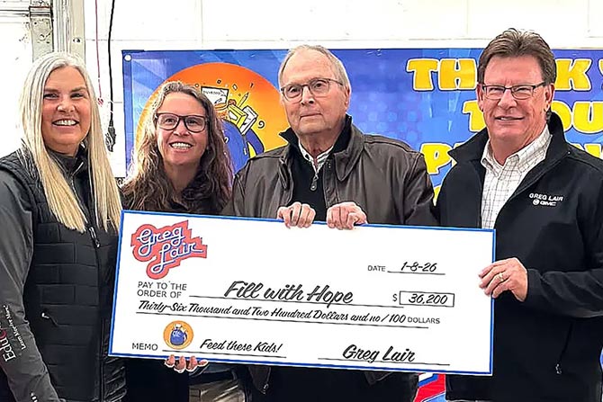 Four people stand smiling and holding a large check for $36,200 made out to "Fill with Hope." The backdrop features a blue banner with text.