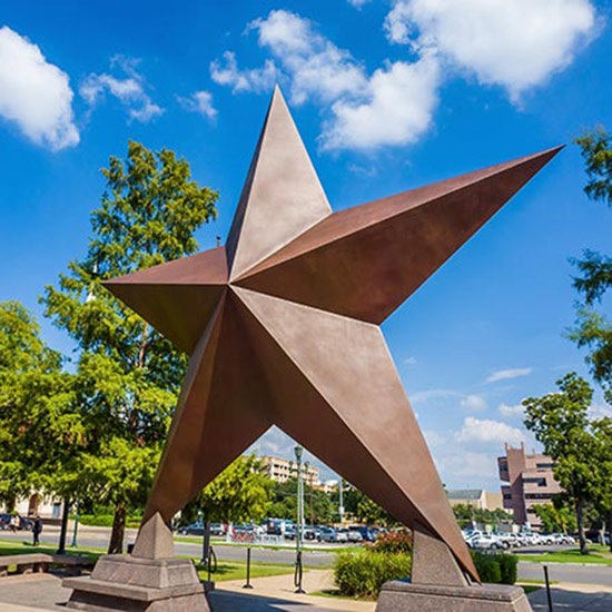 Community News; Bronze star sculpture in an urban park setting under a bright blue sky with white clouds, surrounded by lush green trees and city buildings.